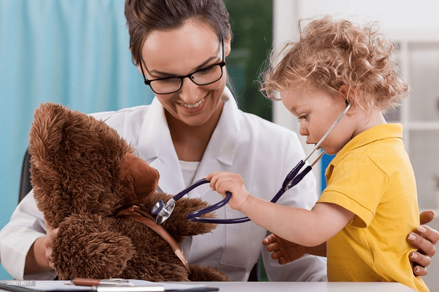 Médica pediatra jugando con su pequeño paciente